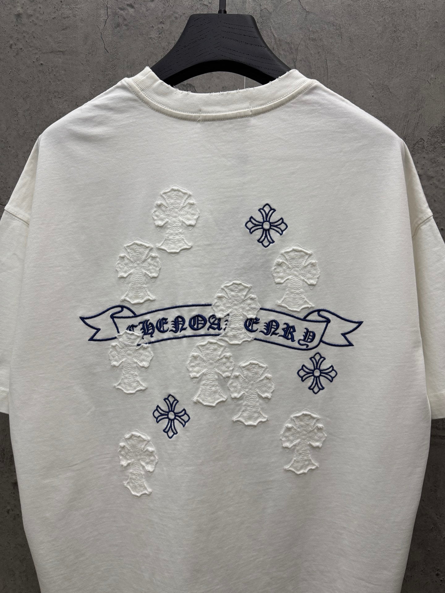 White short-sleeve T-shirt back view with blue banner text and raised snowflake appliques