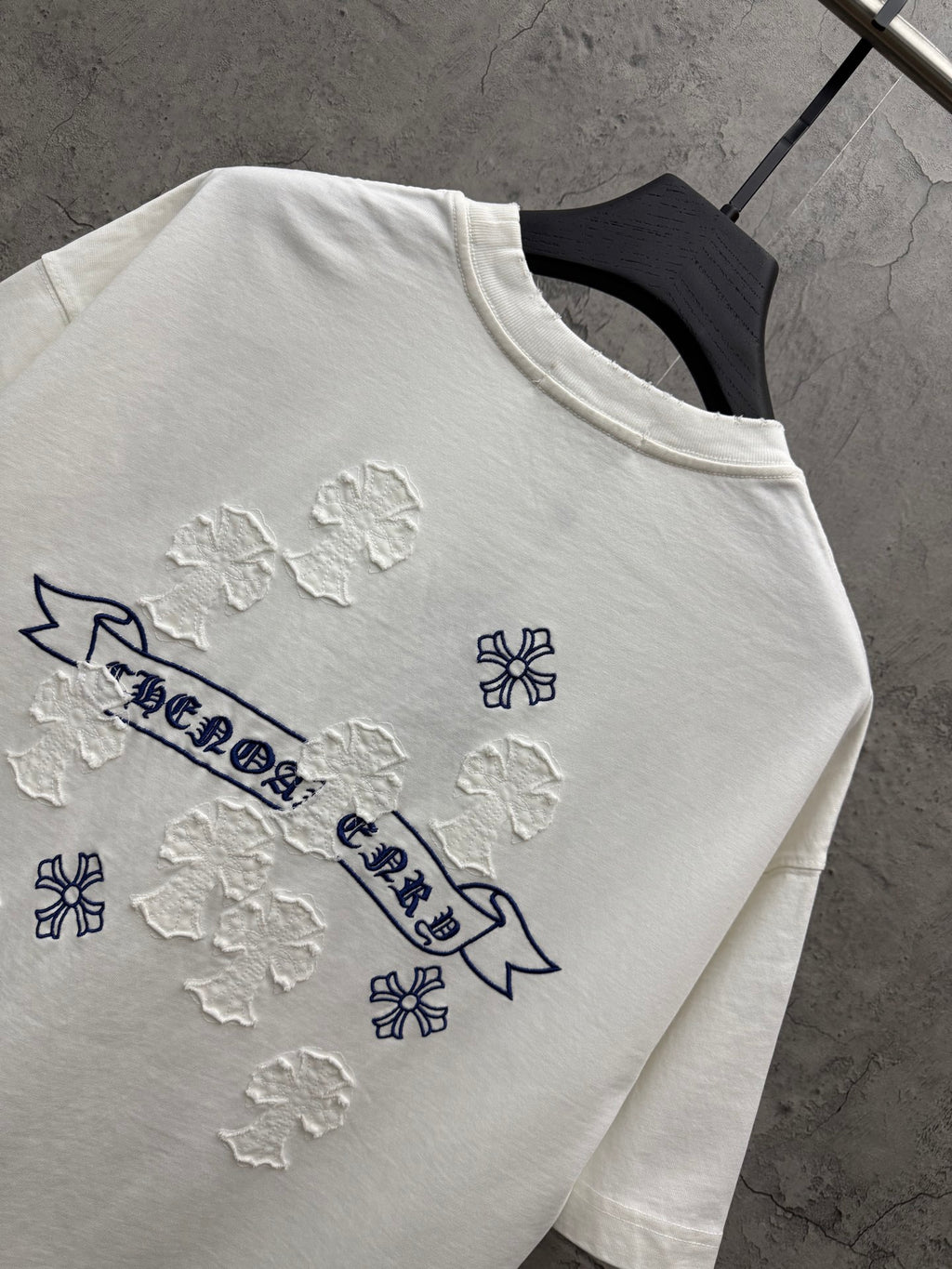 White short-sleeve T-shirt close-up of back graphic with blue banner and raised snowflake patches