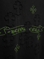 Black short-sleeve T-shirt close-up of green embroidered banner and cross motifs