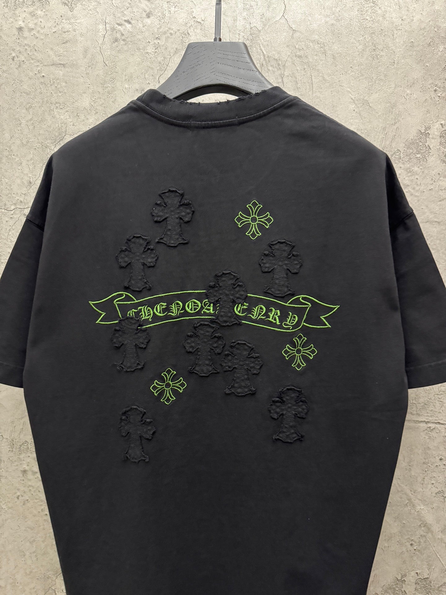 Black short-sleeve T-shirt back view with green banner and clover cross icons