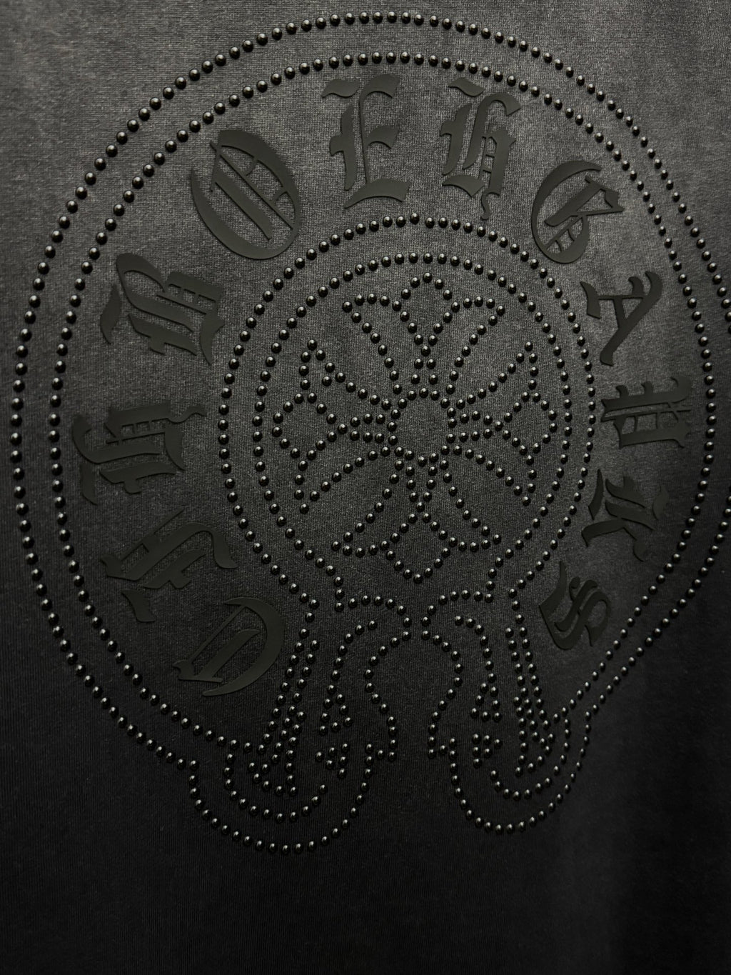 Dark gray T-shirt with large rhinestone skull face graphic, text accents