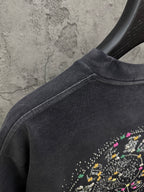 Dark short-sleeve T-shirt shoulder seam with partial studded circular graphic