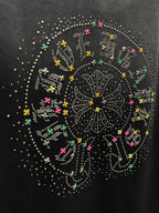 Close-up of studded circular back graphic with colorful accents on dark T-shirt