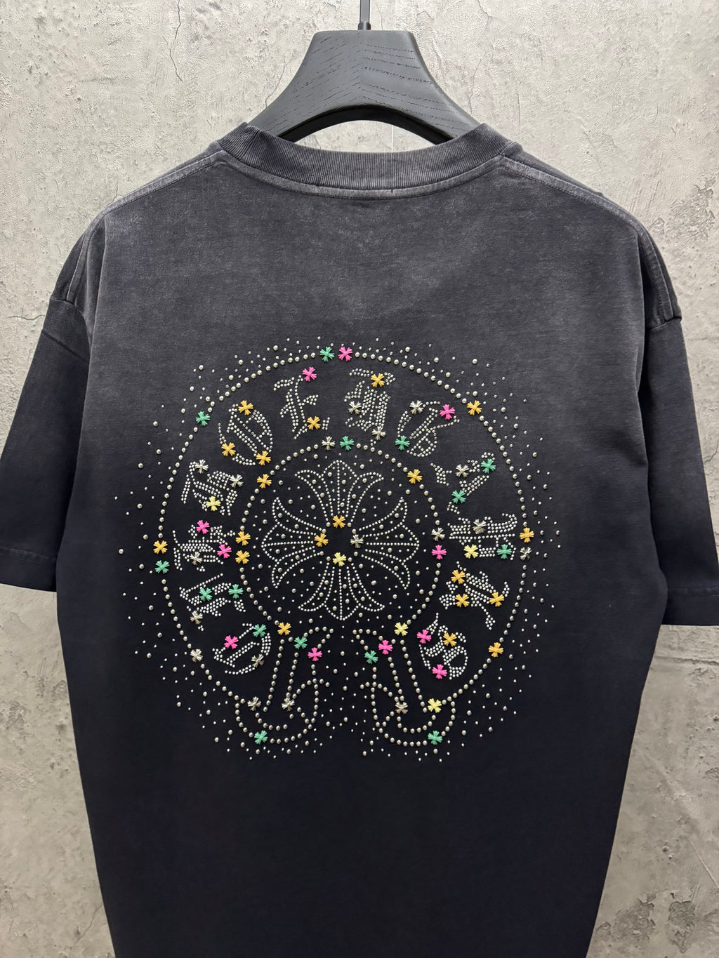 Dark short-sleeve T-shirt, back view, with large studded circular graphic