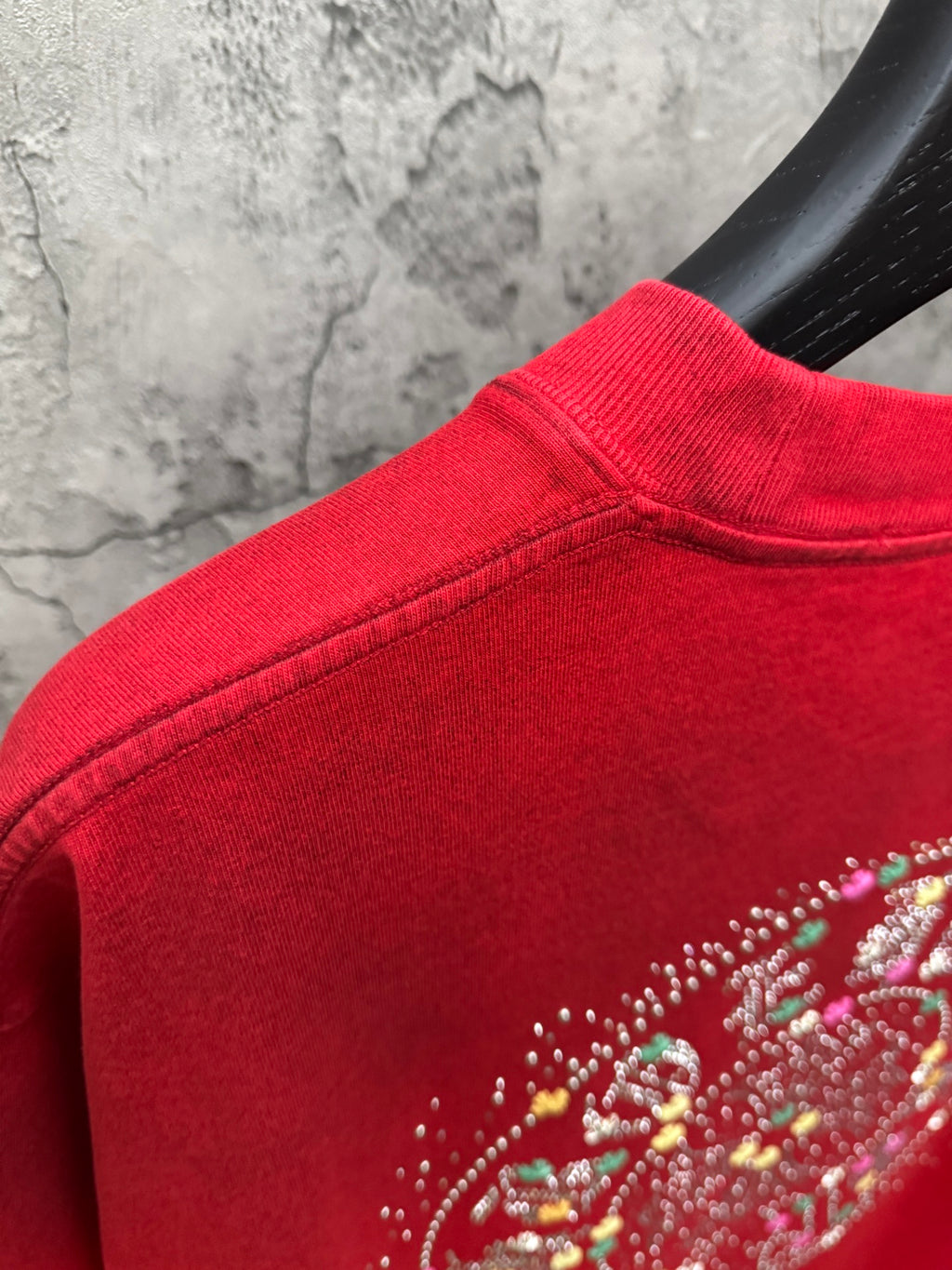 Red T-shirt with studded rhinestone design near shoulder seam
