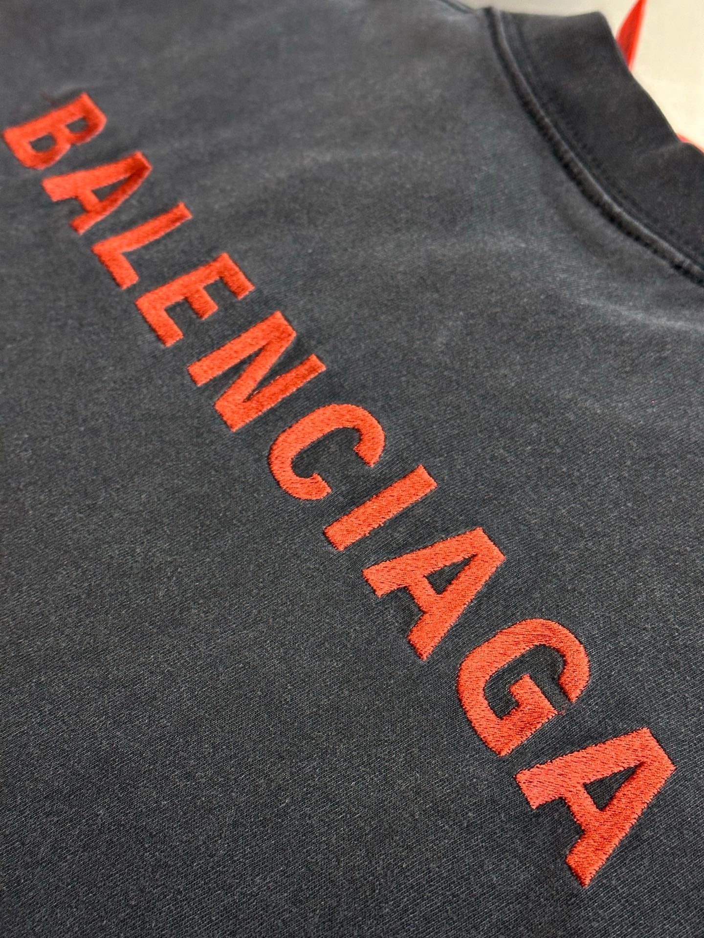 Dark gray T-shirt with large red Balenciaga lettering logo across chest