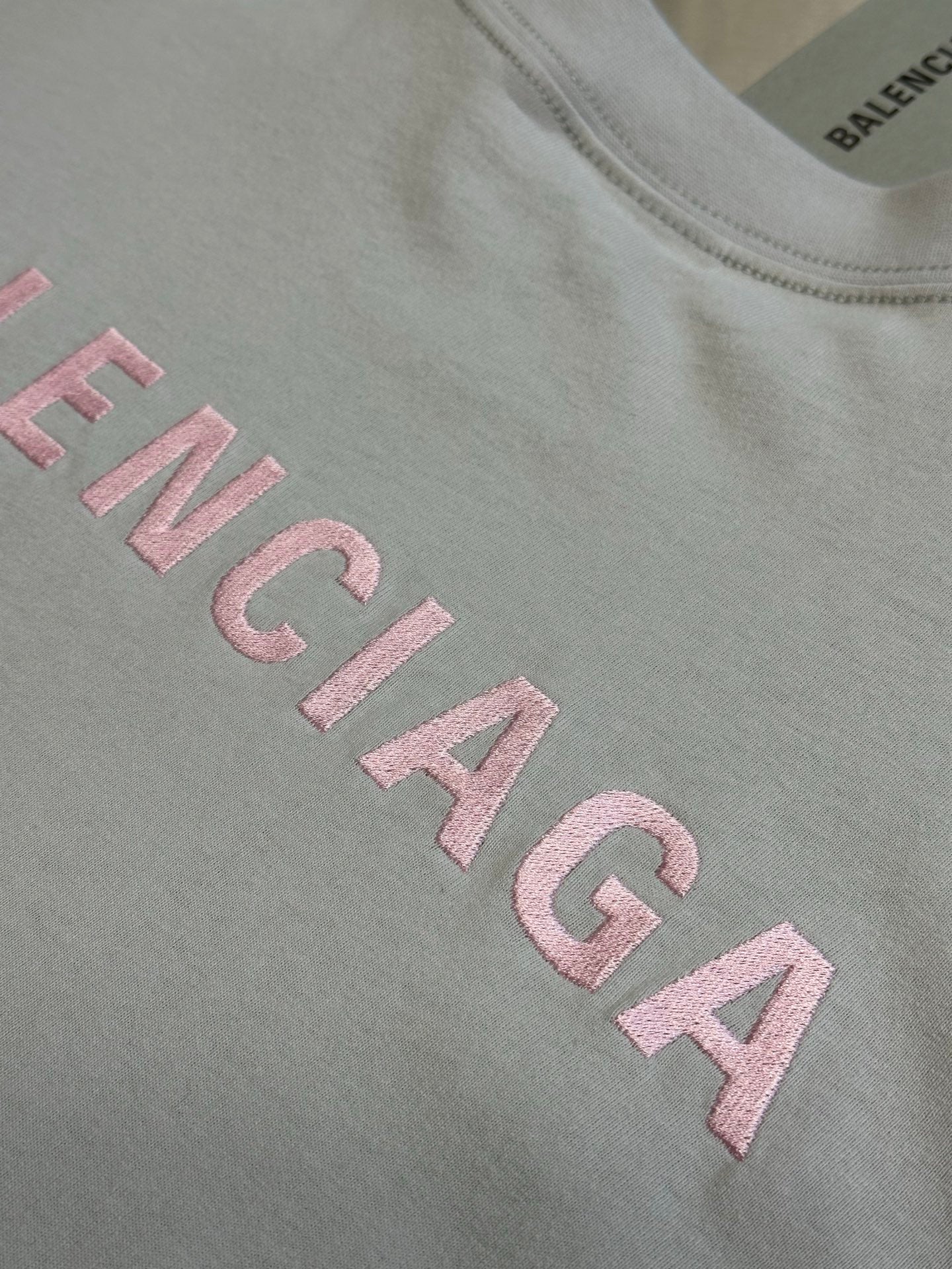 Light gray T-shirt front with large pink BALENCIAGA lettering