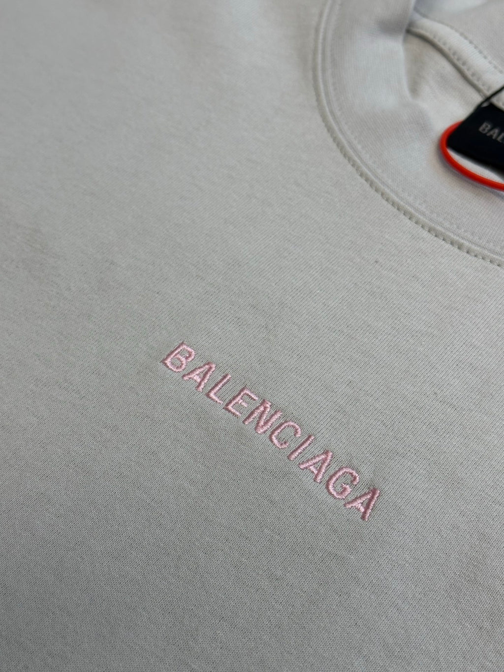 Light gray T-shirt front with pink BALENCIAGA logo text