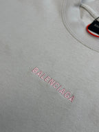 Light gray T-shirt front with pink BALENCIAGA logo text