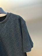 Close-up of navy short-sleeve crewneck T-shirt with allover monogram pattern