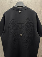 Dark short-sleeve t-shirt with large winged chest emblem centered
