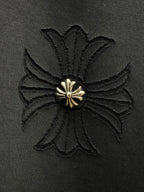 Embroidered flower-like gold emblem on dark fabric