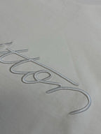 White fabric with Louis Vuitton signature-style embroidery close-up