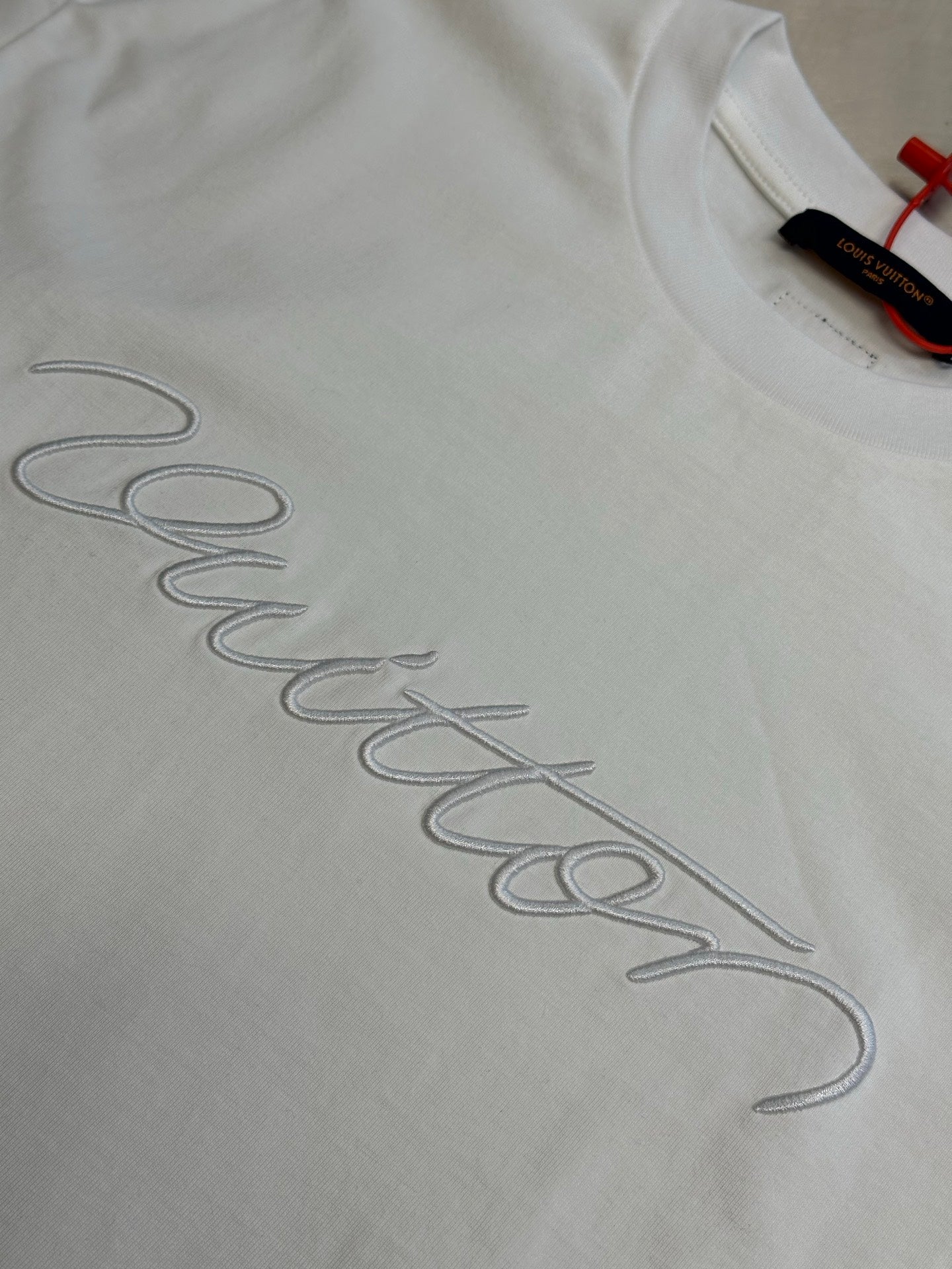 White T-shirt with Louis Vuitton signature-style embroidery across fabric