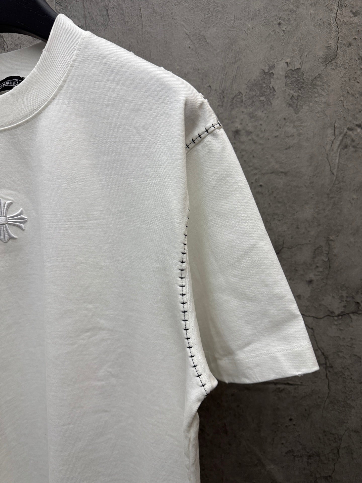 White short-sleeve T-shirt side view with embroidered chest detail
