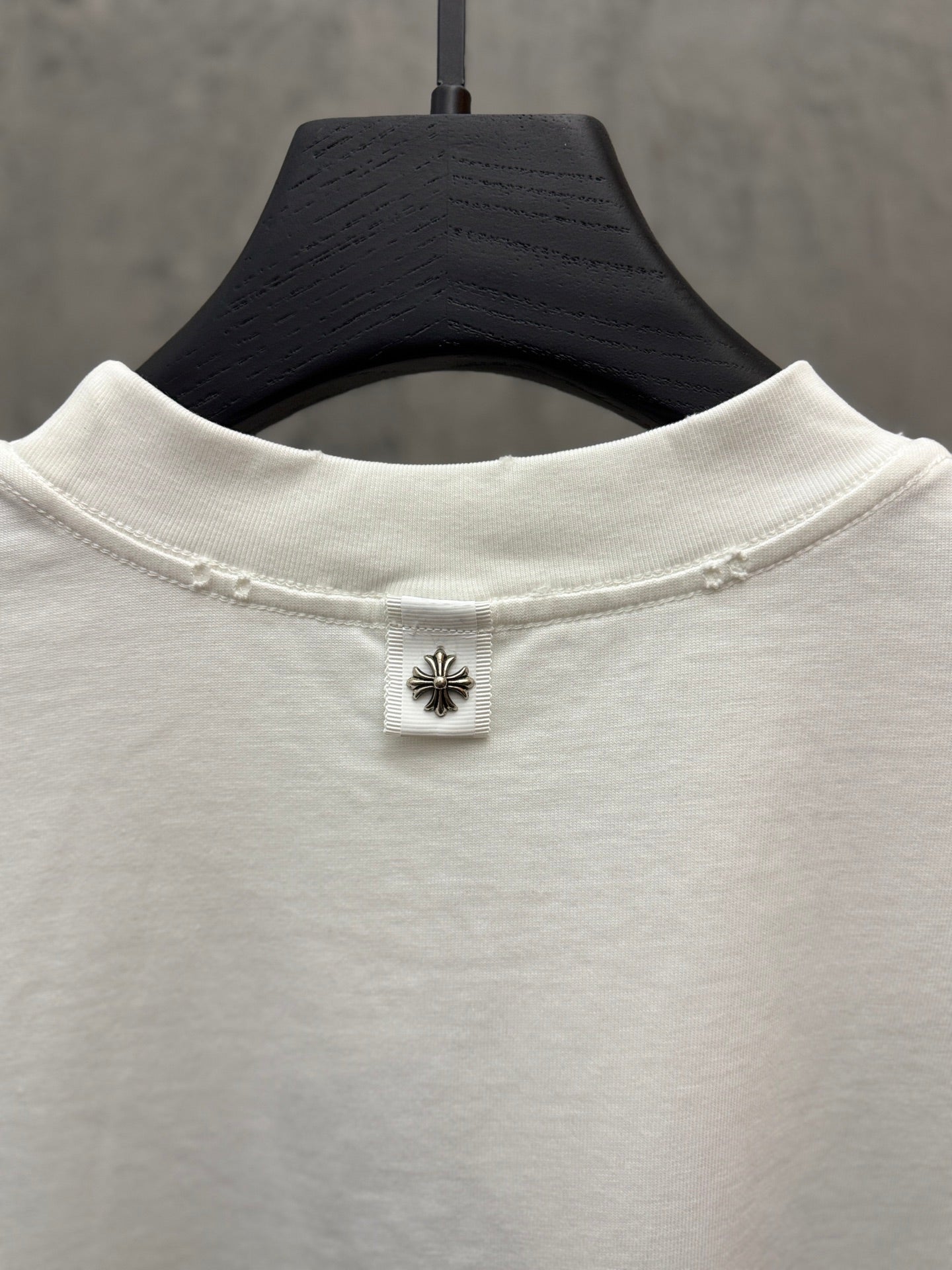 White short-sleeve T-shirt back neck with small hanging label and emblem