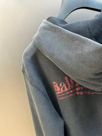 Dark gray hoodie sleeve with red printed logo on upper arm