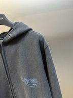 Dark gray zip hoodie with hood and button detail, arched logo print on chest