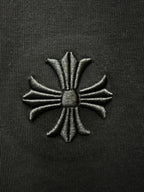 Embroidered floral cross patch on black fabric