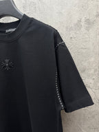 Black long-sleeve style? no—short-sleeve T-shirt with chest emblem and sleeve stud trim