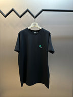 Dior black short-sleeve T-shirt on hanger, front with small green clover logo
