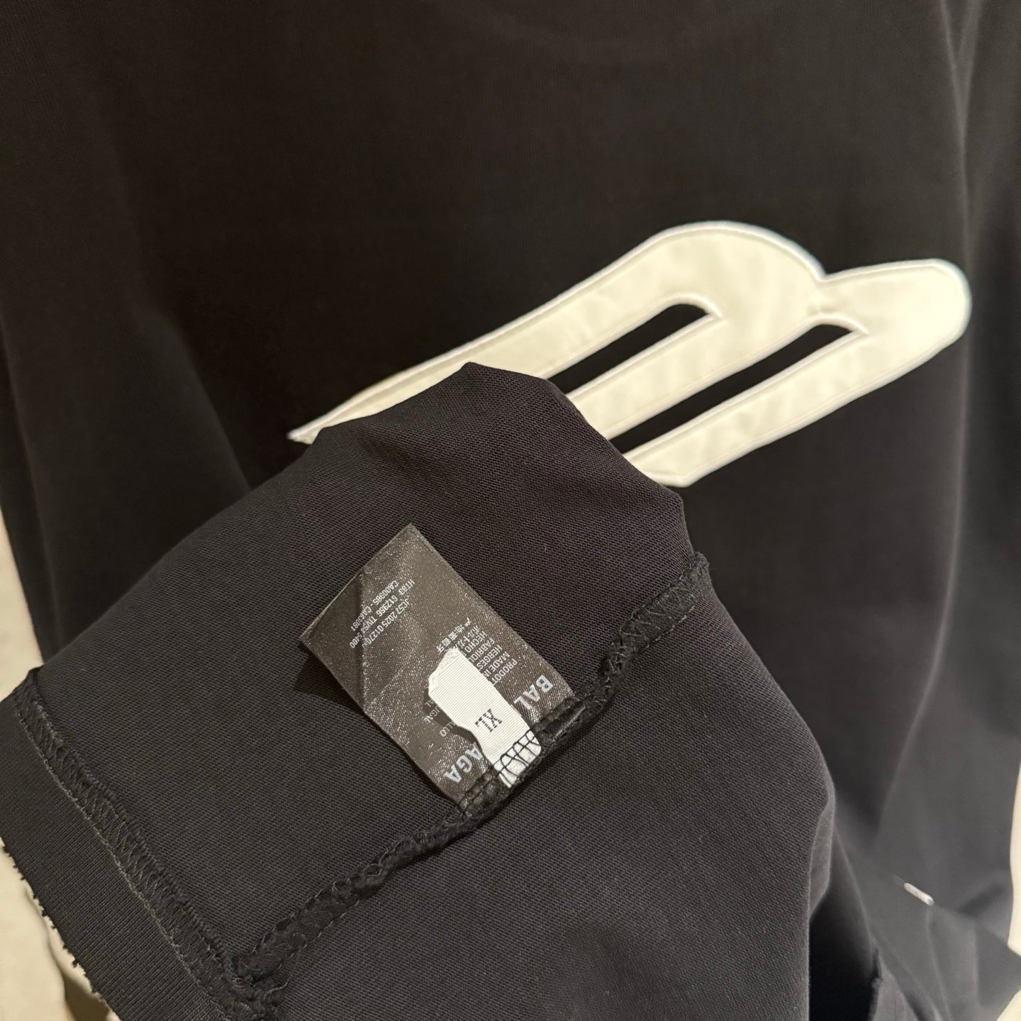 Black T-shirt sleeve and hem with inner care label tag