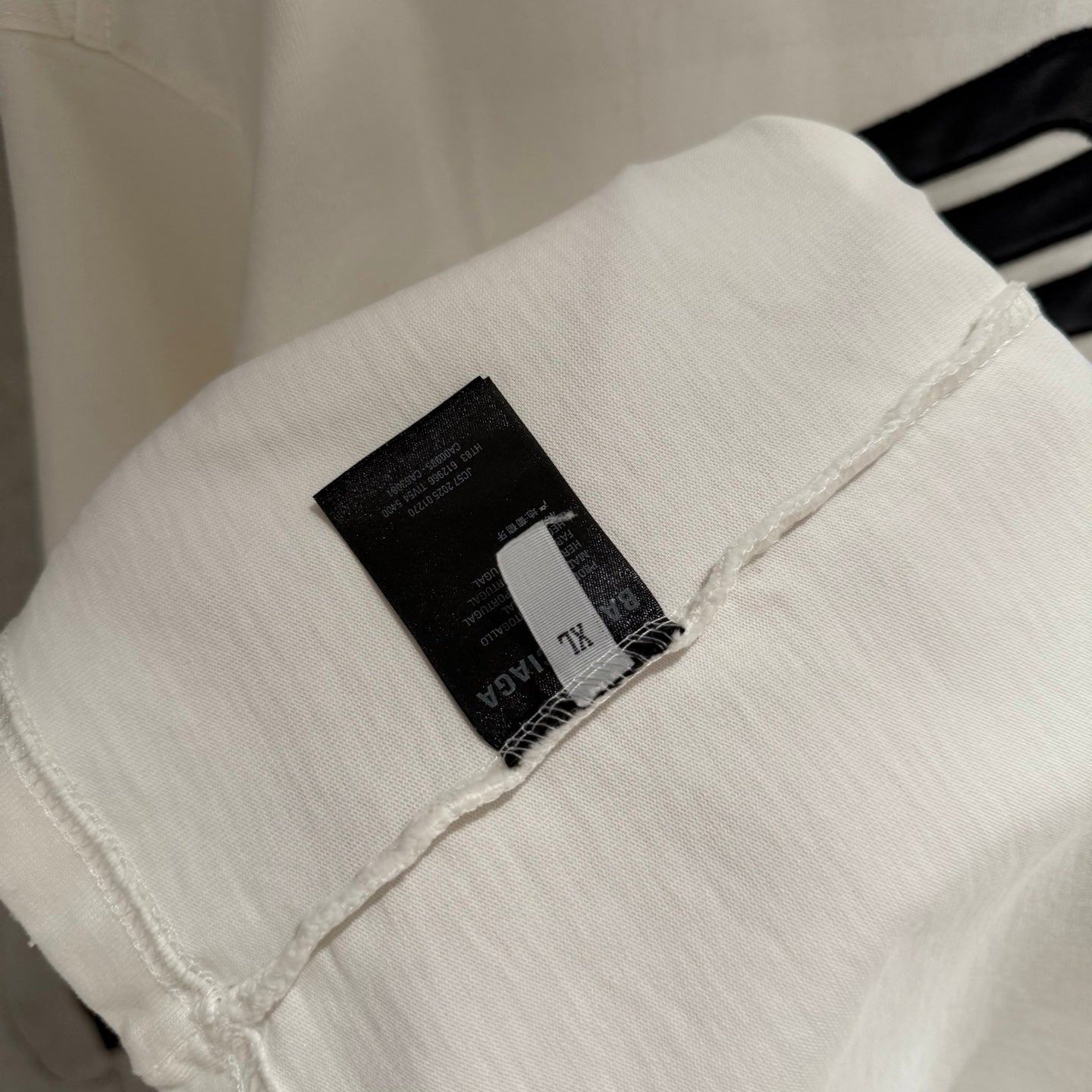White Balenciaga T-shirt sleeve with black brand tag near cuff