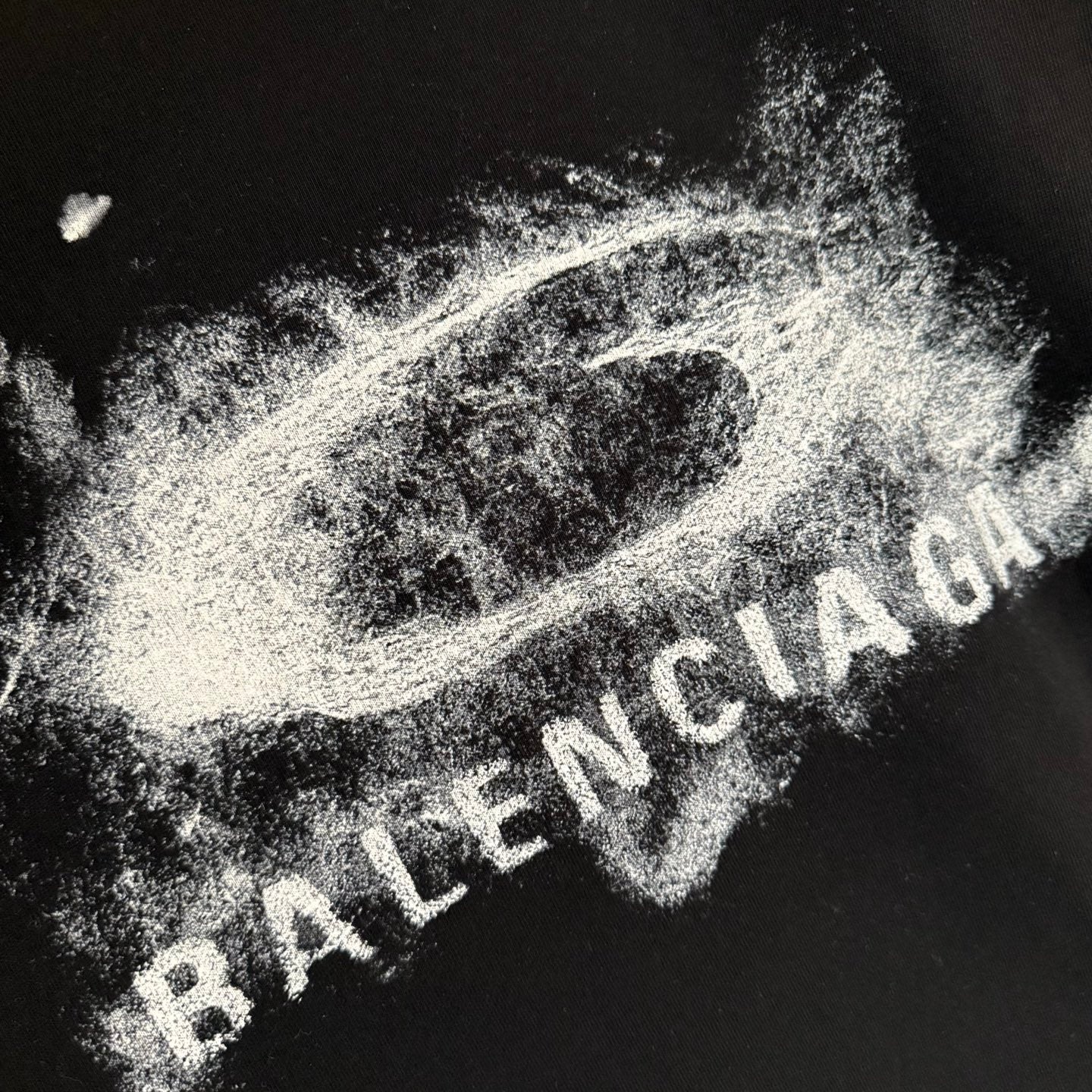 Balenciaga black T-shirt close-up of distressed white logo text graphic