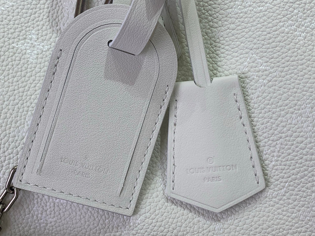 White leather bag strap ends with stitched label tags