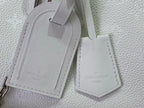 White leather bag strap ends with stitched label tags