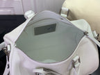 White leather handbag open with zippered top and interior pocket