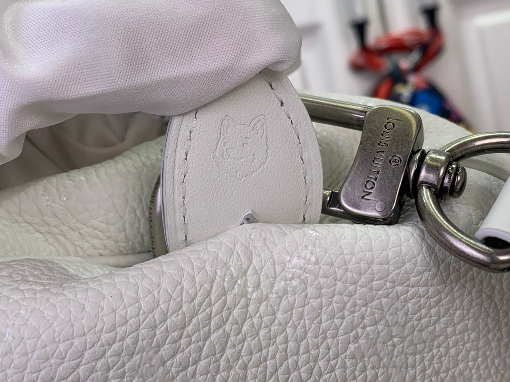 White leather handbag with metal clasp detail on textured side panel