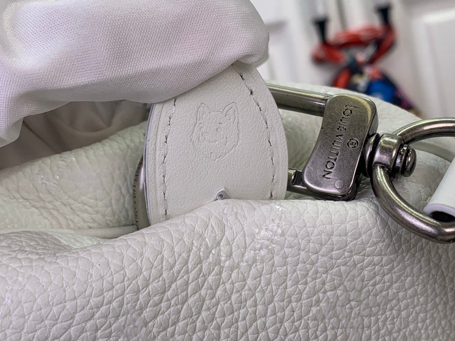 White leather handbag with metal clasp detail on textured side panel