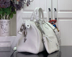 White leather handbag with chain strap and crossbody strap, front charm detail