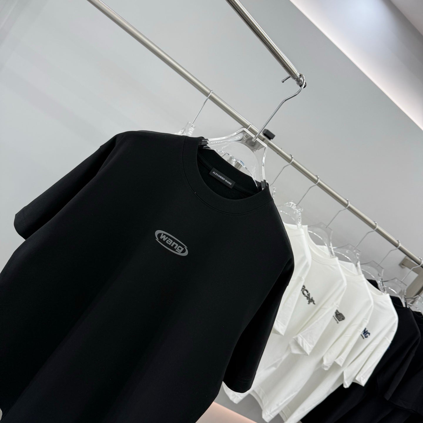 Black short-sleeve T-shirt with wang chest logo on hanger