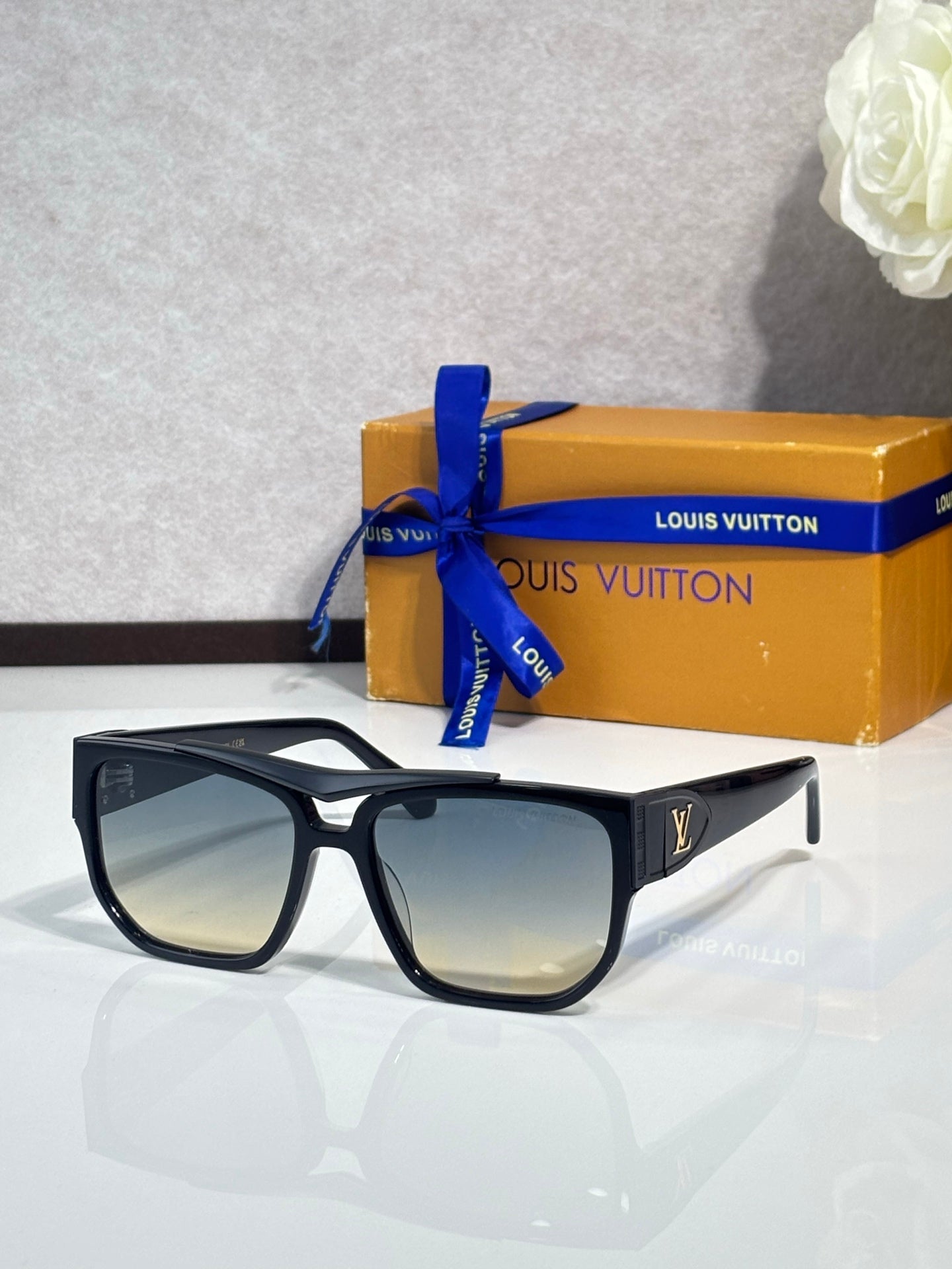 Louis Vuitton sunglasses with black frames and tan gradient lenses