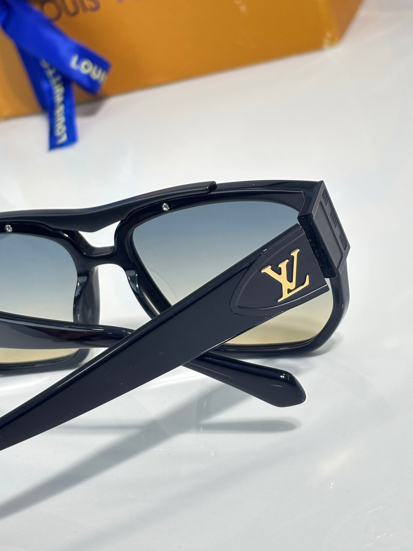 Louis Vuitton sunglasses temple close-up with LV logo on black frame