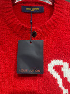 Red cardigan collar close-up with interior brand tag and small black button