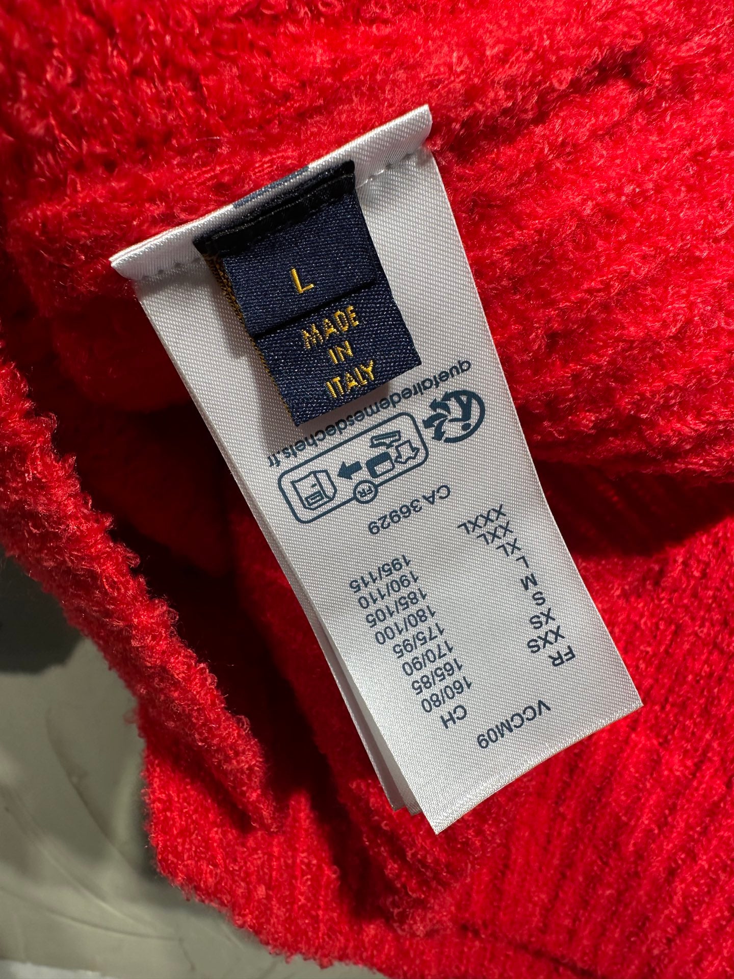 Red knit cardigan care label patch on inner seam