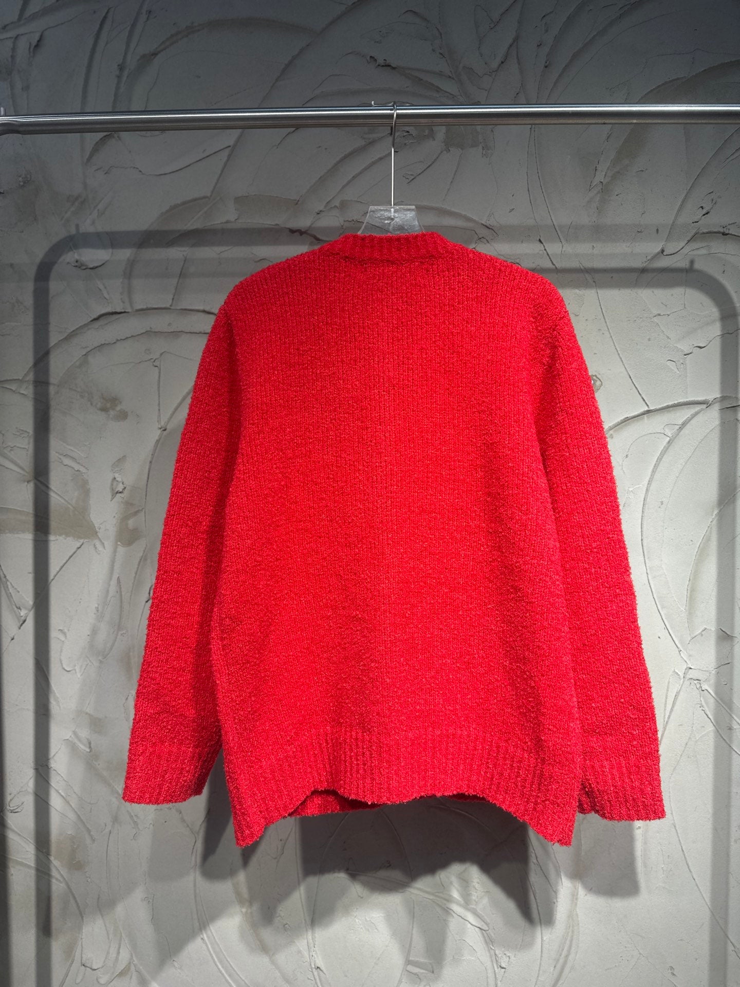 Red cardigan back view with ribbed neckline and textured knit fabric