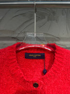 Red cardigan neckline and brand label with small black buttons and hanging tag