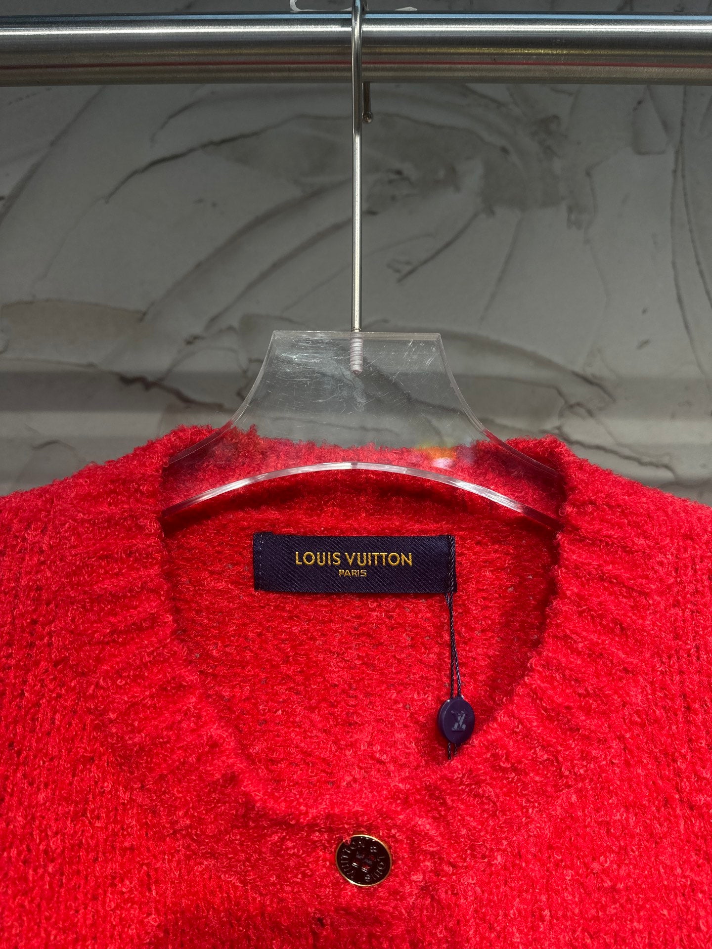Red cardigan neckline and brand label with small black buttons and hanging tag