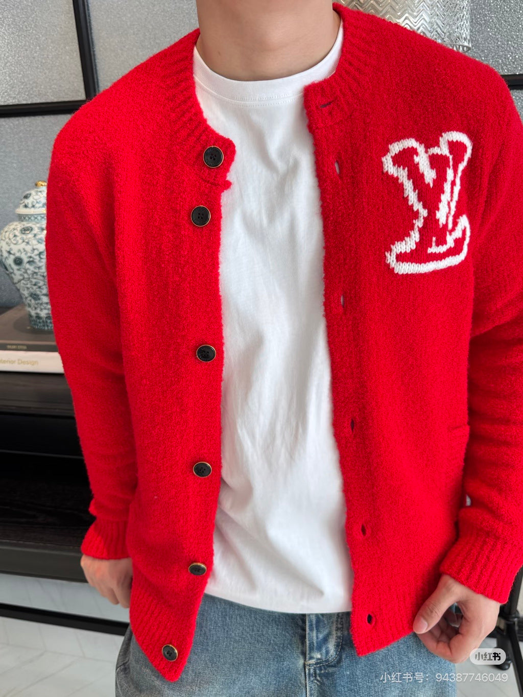 Red knit cardigan jacket with dark buttons and V-style emblem