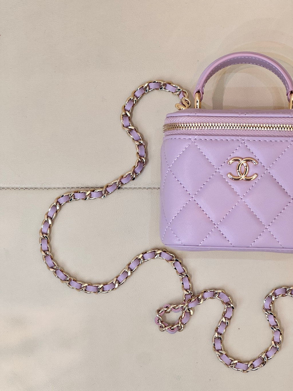 Chanel lavender quilted mini handbag close-up with gold CC logo and zipper front