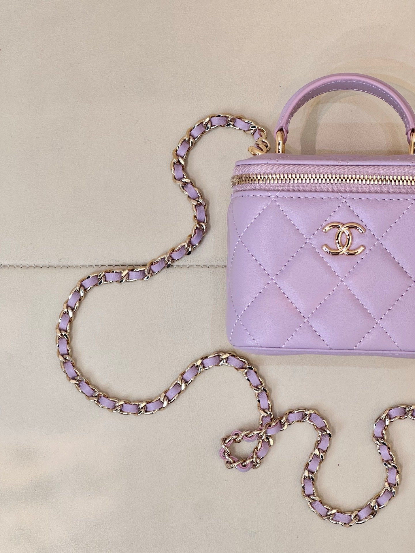 Chanel lavender quilted mini handbag close-up with gold CC logo and zipper front