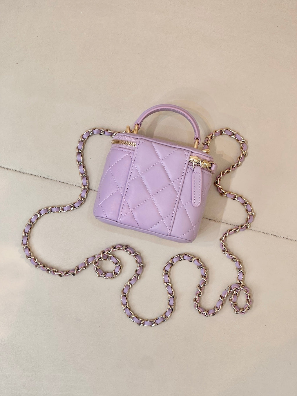 Chanel lavender quilted mini handbag with gold-tone hardware and chain strap close view