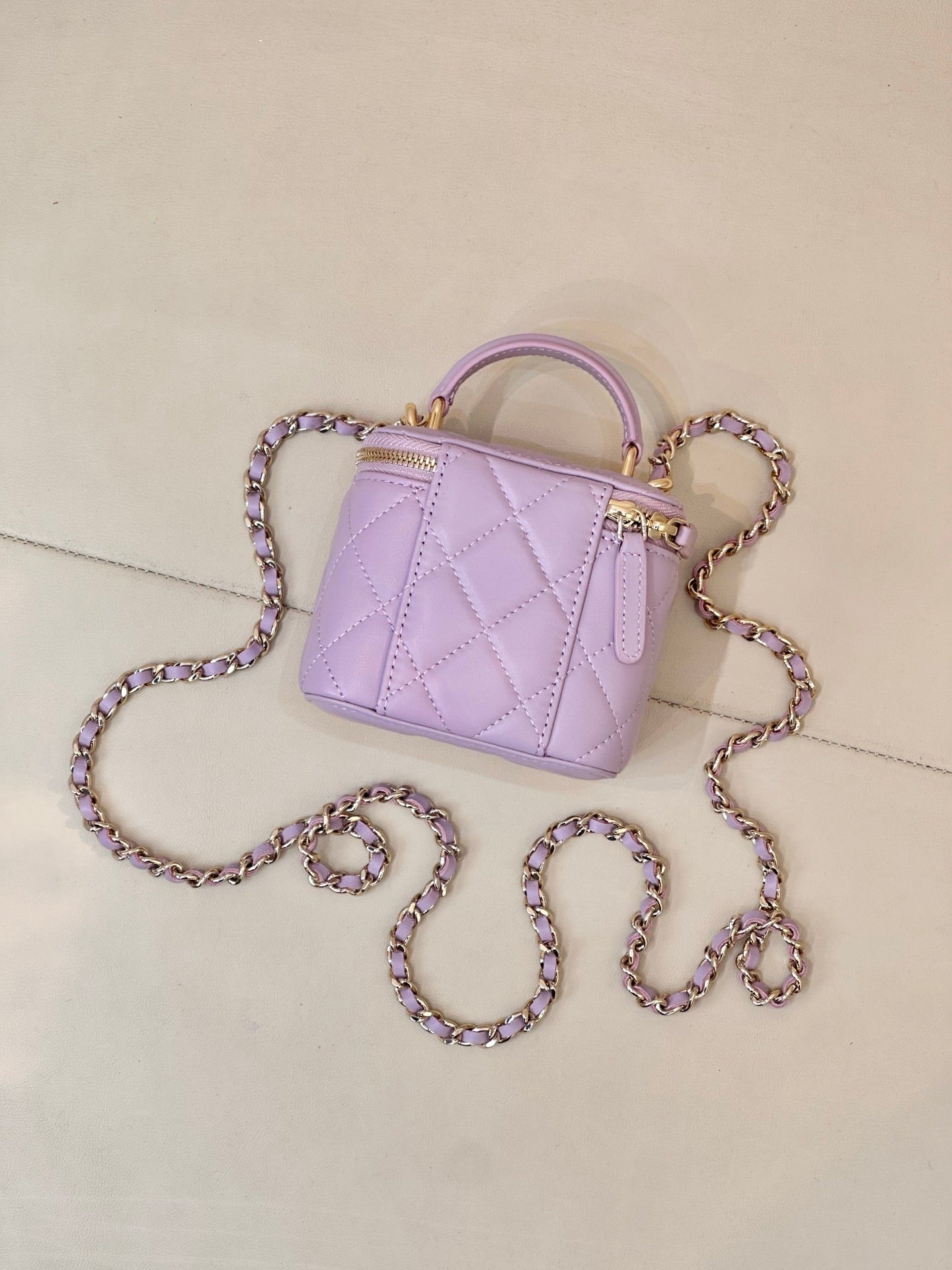 Chanel lavender quilted mini handbag with gold-tone hardware and chain strap close view