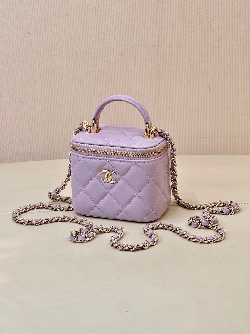 Chanel lavender quilted mini handbag with rounded top handle and gold-tone chain strap