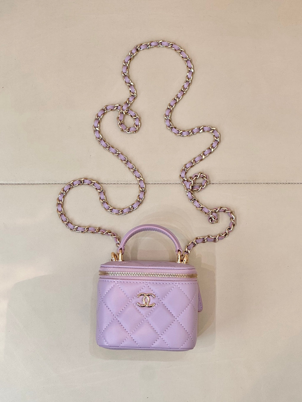 Chanel mini quilted lavender handbag with top handle, chain strap, and gold CC clasp