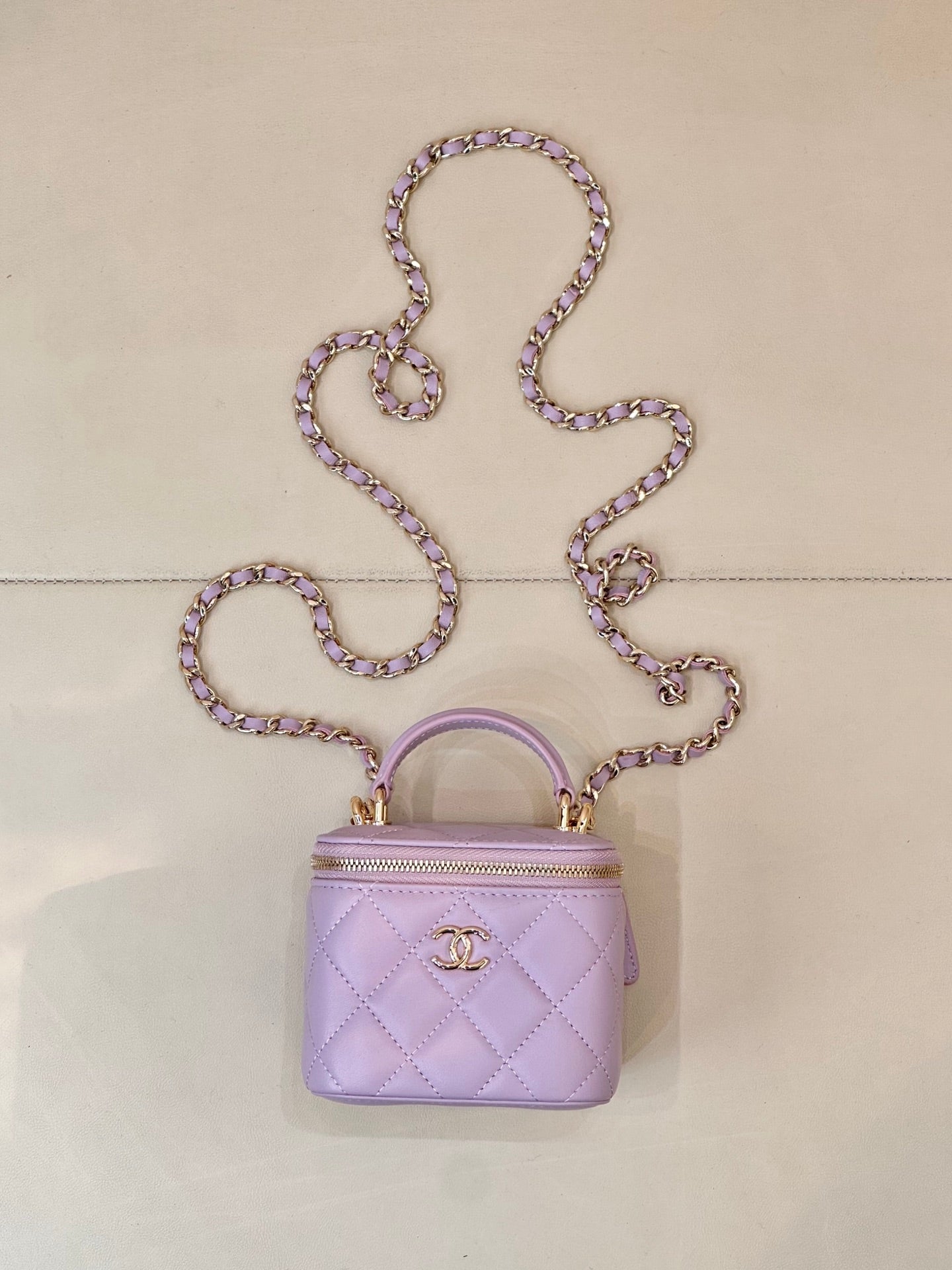 Chanel mini quilted lavender handbag with top handle, chain strap, and gold CC clasp
